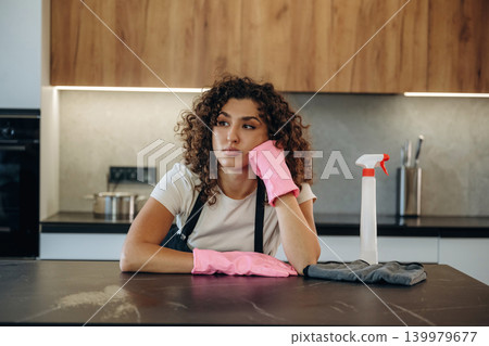 Relaxing, break time. White woman cleaning the kitchen countertop with spray and cloth wearing pink gloves Relaxing, break time. White woman cleaning the kitchen countertop with spray and cloth wearing pink gloves 139979677
