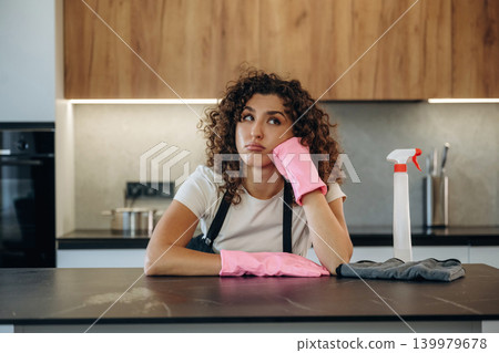 Relaxing, break time. White woman cleaning the kitchen countertop with spray and cloth wearing pink gloves Relaxing, break time. White woman cleaning the kitchen countertop with spray and cloth wearing pink gloves 139979678