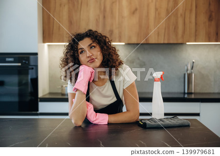 White woman cleaning the kitchen countertop with spray and cloth wearing pink gloves White woman cleaning the kitchen countertop with spray and cloth wearing pink gloves 139979681