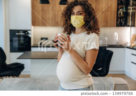 Pregnant woman at home, with belly and enjoying a peaceful moment in a modern kitchen 139979788