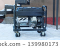 Mobile diesel generator is running outside in winter. Energy independence and electrical equipment. Power supply generator placed in city. 139980173