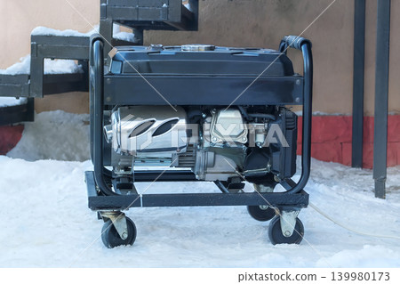 Mobile diesel generator is running outside in winter. Energy independence and electrical equipment. Power supply generator placed in city. Mobile diesel generator is running outside in winter. Energy independence and electrical equipment. Power supply generator placed in city. 139980173