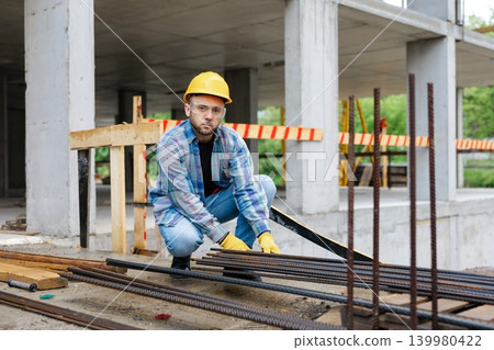 Construction worker inspecting rebar on building site Construction worker inspecting rebar on building site 139980422