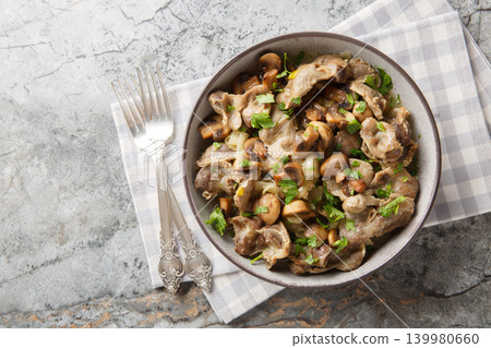 Stir-fried chicken giblets with mushrooms and onions close-up in a bowl. Horizontal top view Stir-fried chicken giblets with mushrooms and onions close-up in a bowl. Horizontal top view 139980660