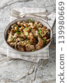 Close-up of stewed chicken gizzards with mushrooms and onions in a bowl. Vertical 139980669