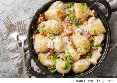 Stewed new potatoes in a creamy mushroom sauce with bacon and breadcrumbs close-up in a frying pan. Horizontal top view Stewed new potatoes in a creamy mushroom sauce with bacon and breadcrumbs close-up in a frying pan. Horizontal top view 139980672