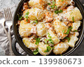 New potatoes served with creamy mushroom sauce, bacon and breadcrumbs close-up in a frying pan. Horizontal top view 139980673