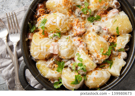 New potatoes served with creamy mushroom sauce, bacon and breadcrumbs close-up in a frying pan. Horizontal top view New potatoes served with creamy mushroom sauce, bacon and breadcrumbs close-up in a frying pan. Horizontal top view 139980673