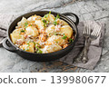 Delicious young potatoes in a creamy mushroom sauce with bacon sprinkled with breadcrumbs and parsley close-up in a frying pan. Horizontal 139980677