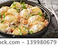 New potatoes served with creamy mushroom sauce, bacon and breadcrumbs close-up in a frying pan. Horizontal 139980679