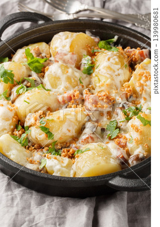 Boiled new potatoes with creamy mushroom sauce and bacon close-up in a frying pan. Vertical Boiled new potatoes with creamy mushroom sauce and bacon close-up in a frying pan. Vertical 139980681