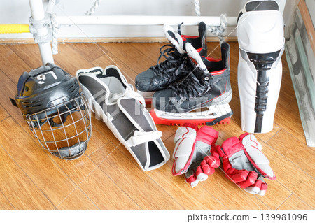 Hockey gear placed on the floor in a training area with various equipment including skates Hockey gear placed on the floor in a training area with various equipment including skates 139981096