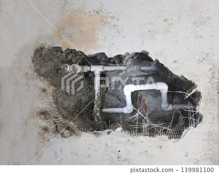 Damaged wall exposing burst water pipes after flood Damaged wall exposing burst water pipes after flood 139981100