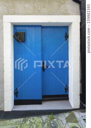 A bright blue double door with black hardware is set in a stone building in Piran, Slovenia 139981393