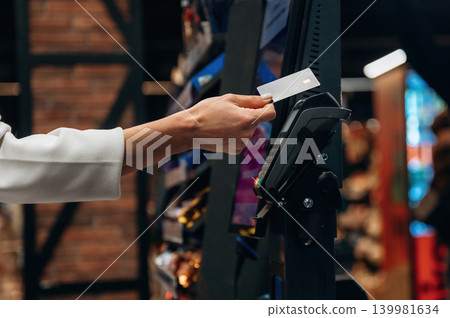 Hand of a customer using a credit card at a payment terminal in a retail store, showcasing modern shopping technology and convenience for consumers Hand of a customer using a credit card at a payment terminal in a retail store, showcasing modern shopping technology and convenience for consumers 139981634