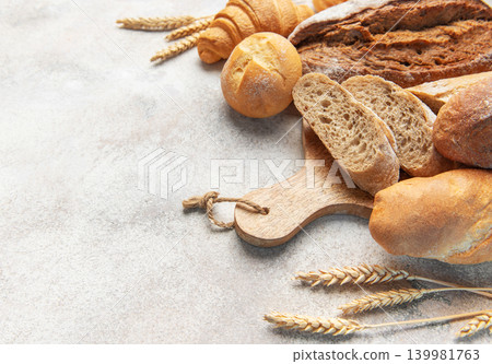 Fresh baked bread assortment with wheat ears on board Fresh baked bread assortment with wheat ears on board 139981763