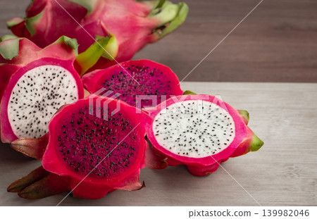 Freshly cut dragon fruit. Slices of delicious pitahaya fruit on wooden background Freshly cut dragon fruit. Slices of delicious pitahaya fruit on wooden background 139982046