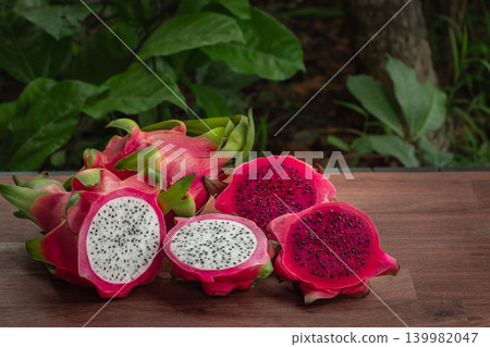 Freshly cut dragon fruit. Slices of delicious pitahaya fruit on wooden background Freshly cut dragon fruit. Slices of delicious pitahaya fruit on wooden background 139982047