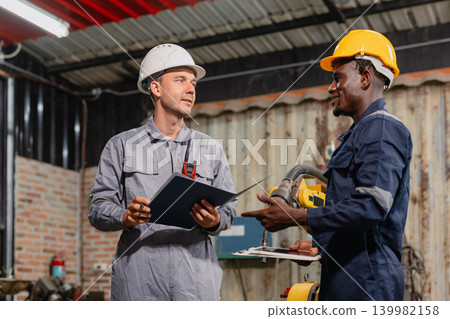 Professional engineer workers team working in metal workshop talking and working together Professional engineer workers team working in metal workshop talking and working together 139982158