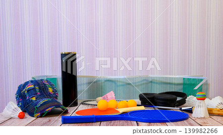 set of various sports equipment for active games on a wooden table near a wall set of various sports equipment for active games on a wooden table near a wall 139982266