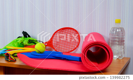 sports items rackets boomerangs and a mat on a wooden table sports items rackets boomerangs and a mat on a wooden table 139982275