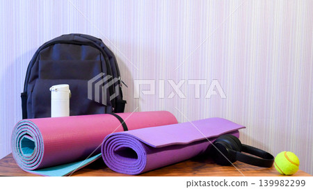 fitness equipment set with mats a backpack and headphones on a table fitness equipment set with mats a backpack and headphones on a table 139982299