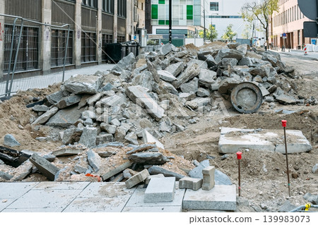 Broken concrete and asphalt debris sit in large pile at urban construction site. Urban renewal, infrastructure development, city transformation, material recycling. Broken concrete and asphalt debris sit in large pile at urban construction site. Urban renewal, infrastructure development, city transformation, material recycling. 139983073