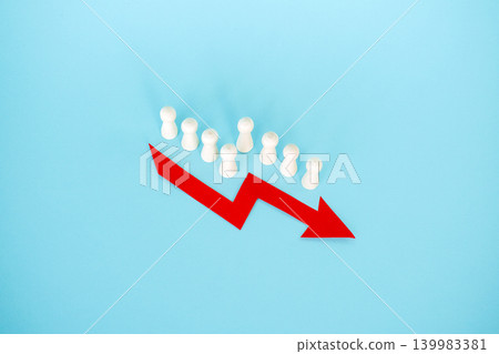 Line of wooden peg dolls stands behind red downward arrow on blue surface. Declining birth rate, demographic collapse trend, aging population crisis, Population shrinking statistics. Line of wooden peg dolls stands behind red downward arrow on blue surface. Declining birth rate, demographic collapse trend, aging population crisis, Population shrinking statistics. 139983381