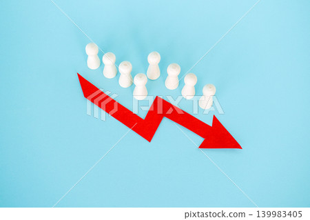 Line of wooden peg dolls stands behind red downward arrow on blue background. Population shrinking statistics, fertility rate drop, societal aging impact, Human capital depletion. 139983405