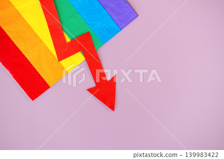 Red downward arrow pointed away from rainbow flag on purple surface. Corporate DEI budget cuts, workplace inclusion rollback, diversity program defunding, Equity initiative decline. Red downward arrow pointed away from rainbow flag on purple surface. Corporate DEI budget cuts, workplace inclusion rollback, diversity program defunding, Equity initiative decline. 139983422
