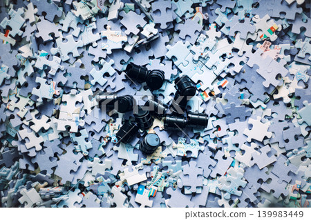 Group of small black barrels resting on top of world map puzzle pieces. Energy supply chain threats, critical resource management, global oil production. Group of small black barrels resting on top of world map puzzle pieces. Energy supply chain threats, critical resource management, global oil production. 139983449