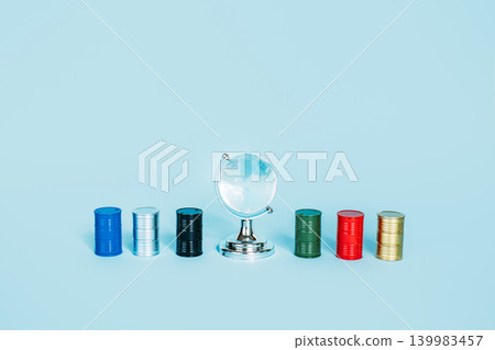 Glass globe sits surrounded by colorful miniature oil barrels on light blue background. Global oil dependency, fossil fuel foundation, energy-driven world economy. Glass globe sits surrounded by colorful miniature oil barrels on light blue background. Global oil dependency, fossil fuel foundation, energy-driven world economy. 139983457