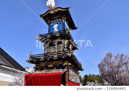 The Inuyama Festival in Aichi Prefecture, Japan: A magnificent procession of elaborate floats called "Kurumayama" and the keep of Inuyama Castle, under a sky full of blooming cherry blossoms. The Inuyama Festival in Aichi Prefecture, Japan: A magnificent procession of elaborate floats called "Kurumayama" and the keep of Inuyama Castle, under a sky full of blooming cherry blossoms. 139984461