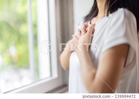 Close-up of a woman's hand on her chest. Close-up of a woman's hand on her chest. 139984472