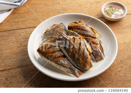 Fried Sun dried tilapia fish in a plate. Fried Sun dried tilapia fish in a plate. 139984540