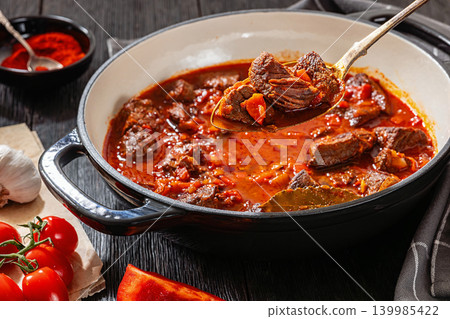 Spoon picking beef chunk from goulash stew Spoon picking beef chunk from goulash stew 139985422