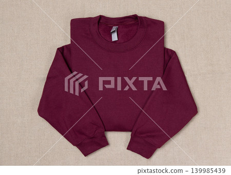 Blank dark red unisex sweatshirt mockup, folded apparel template, copy space on front and sleeves Blank dark red unisex sweatshirt mockup, folded apparel template, copy space on front and sleeves 139985439