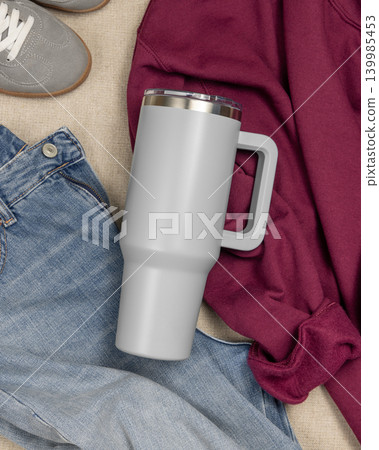 Blank grey 40oz tumbler mockup, stainless steel travel thermos on denim and dark red sweatshirt Blank grey 40oz tumbler mockup, stainless steel travel thermos on denim and dark red sweatshirt 139985453