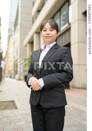 A Japanese woman in her 20s working in an office, arms crossed. 139985991