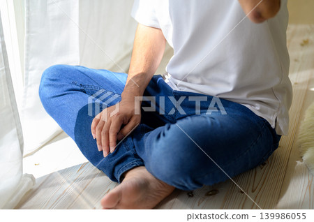 A Japanese man thinking by the window 139986055