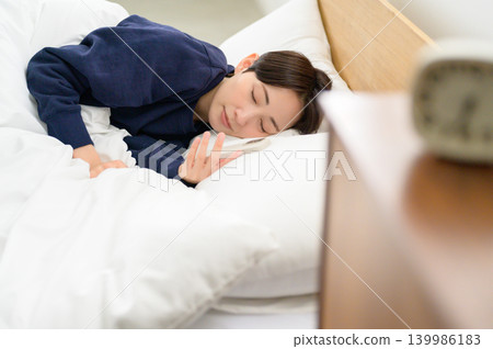 日本女子看著智慧型手機睡著了 日本女子看著智慧型手機睡著了 139986183