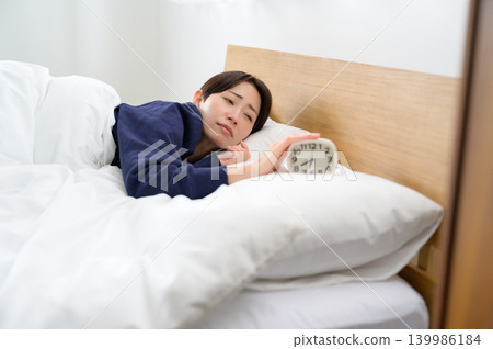 一名日本女子因睡眠不足而關掉了鬧鐘。 一名日本女子因睡眠不足而關掉了鬧鐘。 139986184