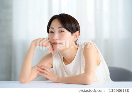 A beauty image of a Japanese woman resting her chin on her hand. A beauty image of a Japanese woman resting her chin on her hand. 139986188