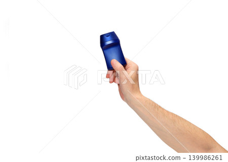 person holding a blue cosmetic bottle at an angle on a white background person holding a blue cosmetic bottle at an angle on a white background 139986261