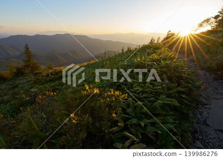 夕陽西下,映照著山脊上的山徑。 夕陽西下,映照著山脊上的山徑。 139986276