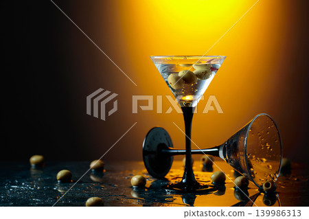 Green olives and glass of martini on a black stone table. Green olives and glass of martini on a black stone table. 139986313