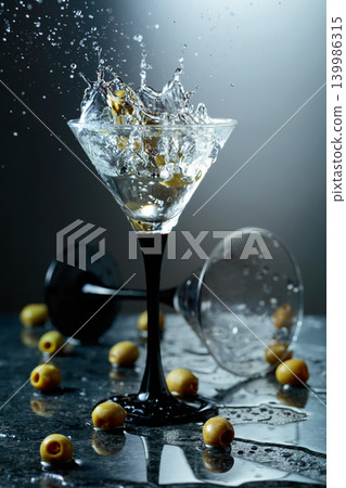 Green olives and glass of martini on a black stone table. Green olives and glass of martini on a black stone table. 139986315