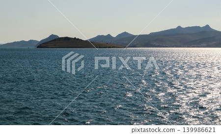 Aegean Sea sparkling water with coastline and mountains near Bitez, Bodrum, Turkey under clear sky Aegean Sea sparkling water with coastline and mountains near Bitez, Bodrum, Turkey under clear sky 139986621