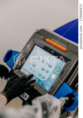 Close-up of a professional laser hair removal device in a beauty clinic. Non-invasive aesthetic medicine, cosmetic procedures, skincare, and body care concept. Modern equipment used for hair removal Close-up of a professional laser hair removal device in a beauty clinic. Non-invasive aesthetic medicine, cosmetic procedures, skincare, and body care concept. Modern equipment used for hair removal 139986815