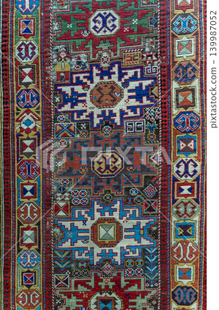 Detailed view of a traditional Azerbaijani Zeiva carpet in Cuban style featuring intricate ornamental patterns, rich colors, and authentic woven textile texture. Oriental handmade rug background Detailed view of a traditional Azerbaijani Zeiva carpet in Cuban style featuring intricate ornamental patterns, rich colors, and authentic woven textile texture. Oriental handmade rug background 139987052